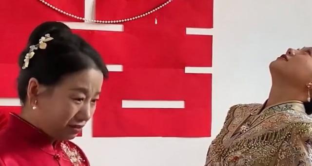 母亲不舍女儿出嫁掉眼泪，新娘仰头掩盖泪水浸湿的面庞：两家人了